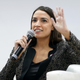 Alexandria Ocasio-Cortez speaking into a microphone at COP26